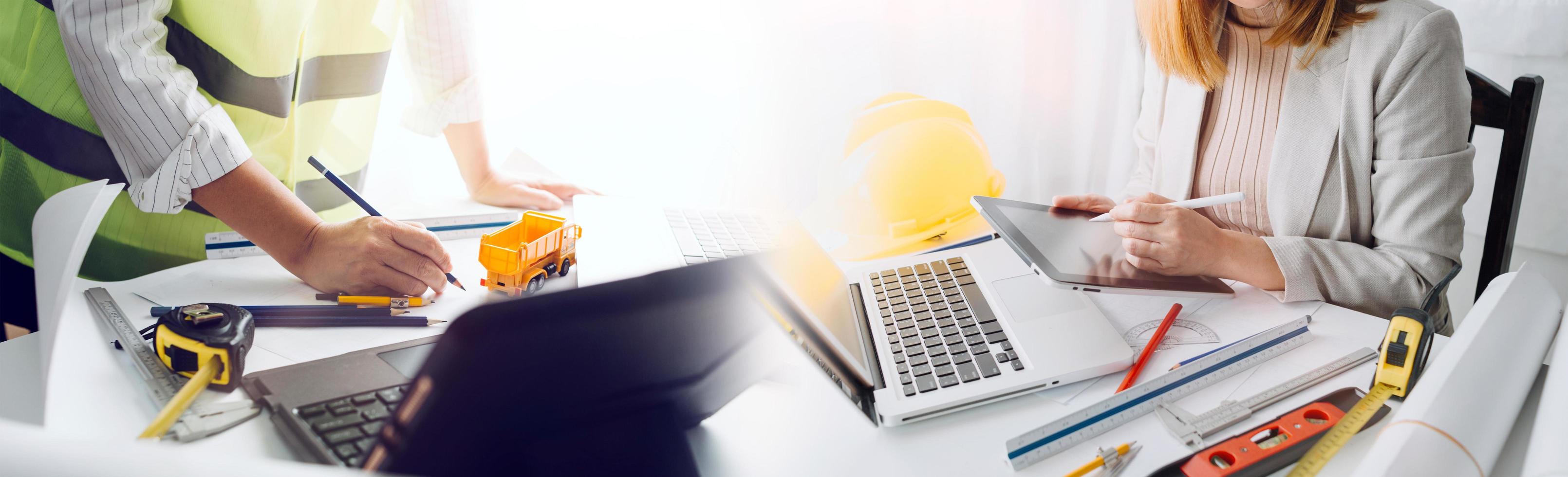 business hand working and laptop with on on architectural project at construction site at office desk in office photo