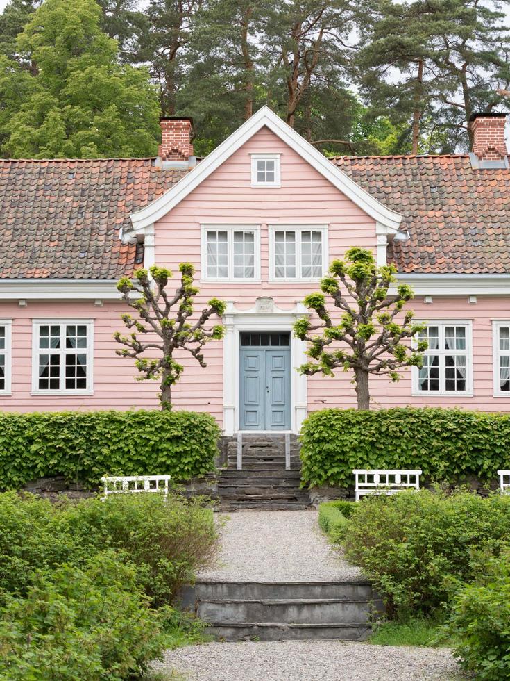 Oslo, Norway. May 29, 2022. A pink house with a blue door at The Norwegian Museum of Cultural History in Oslo. photo