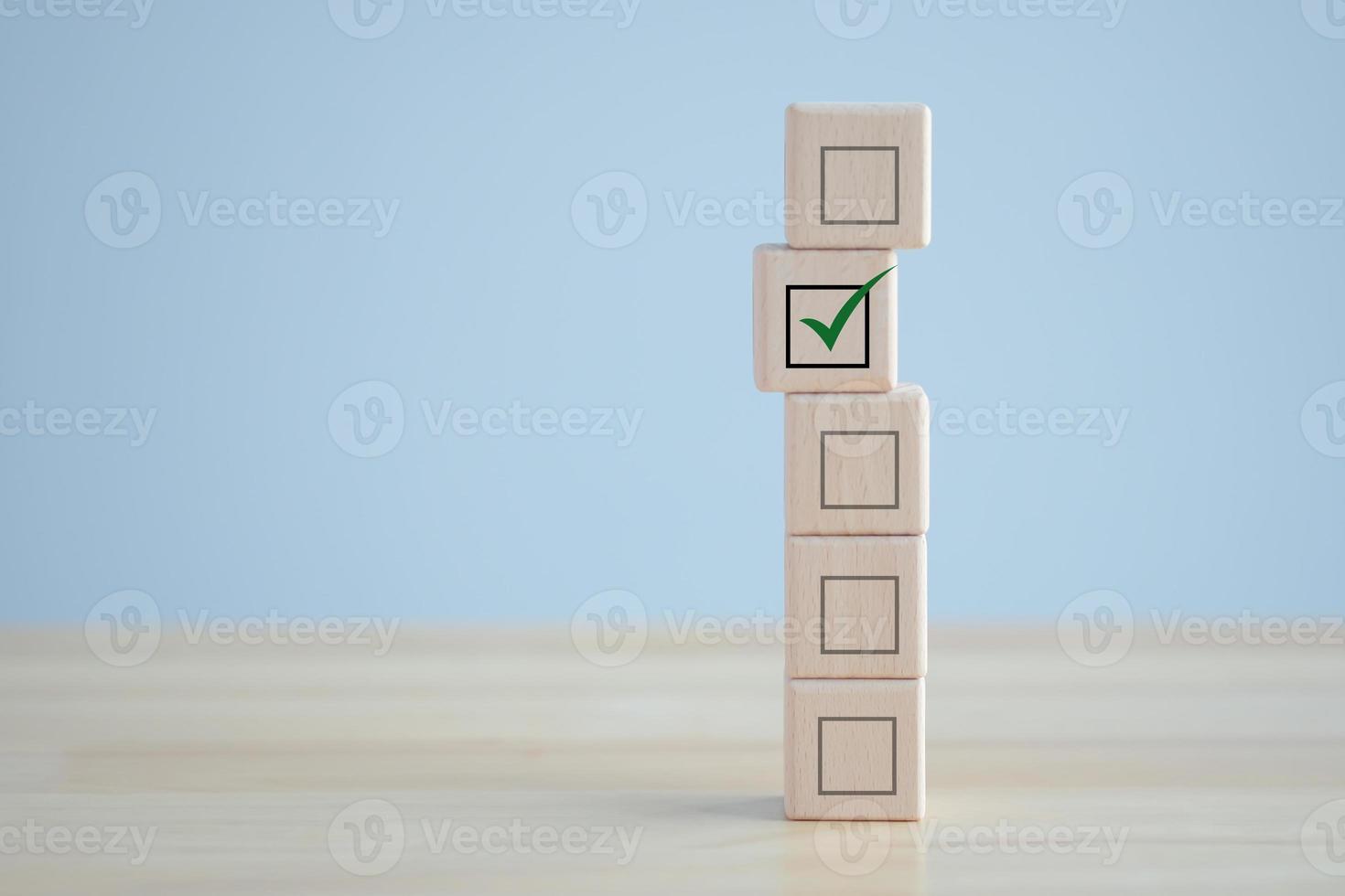 elecciones y votación, votación, lista de tareas, lista de verificación, lista de tareas, examen, encuesta y concepto de evaluación. marca de verificación en bloque de madera y casilla de verificación en blanco en cubos de madera. foto