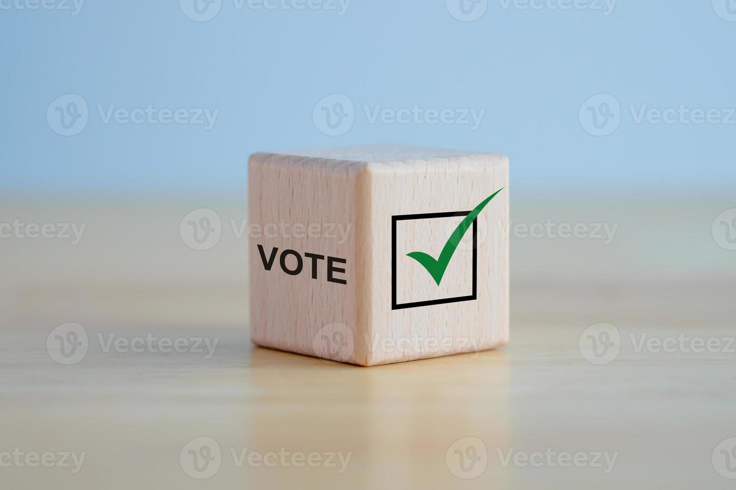 Elections and Voting concept. Check mark and VOTE text on wooden block. photo