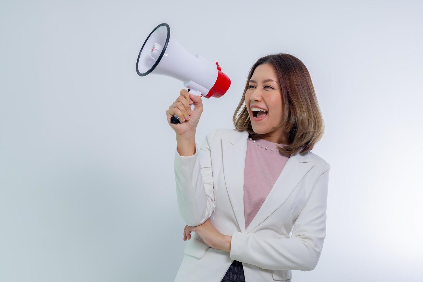 mujer asiática sosteniendo megáfono, habla y anuncia el concepto. foto