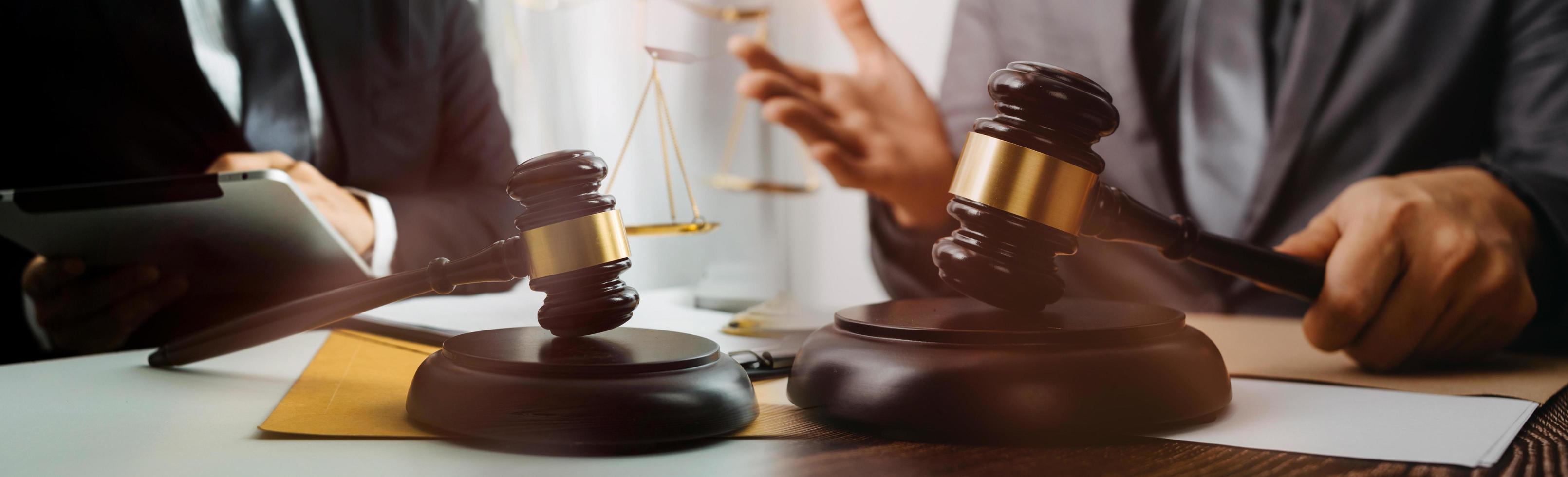 Justice and law concept.Male judge in a courtroom with the gavel, working with, computer and docking keyboard, eyeglasses, on table in morning light photo