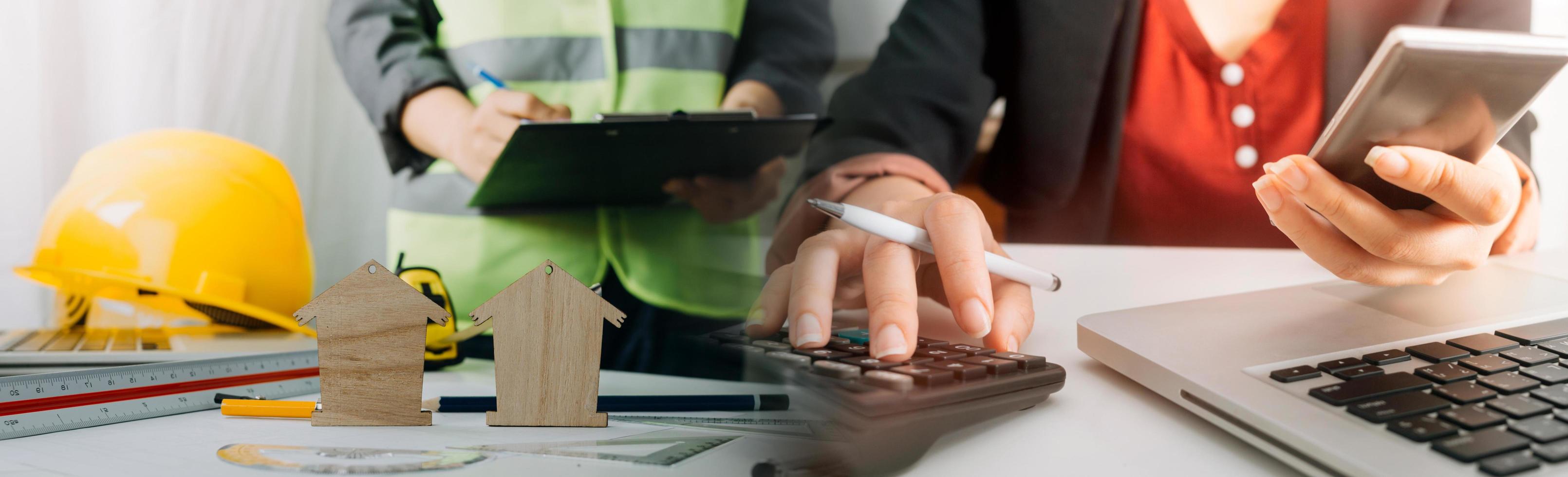 Two colleagues discussing data working and tablet, laptop with on on architectural project at construction site at desk in office photo