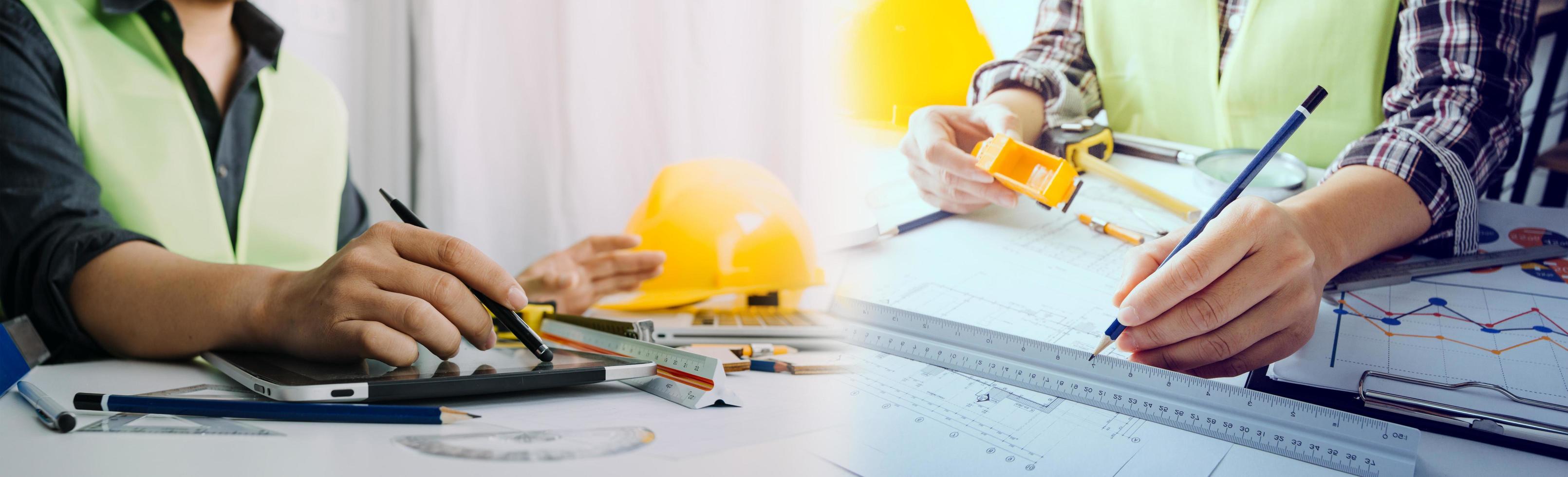 business hand working and laptop with on on architectural project at construction site at office desk in office photo