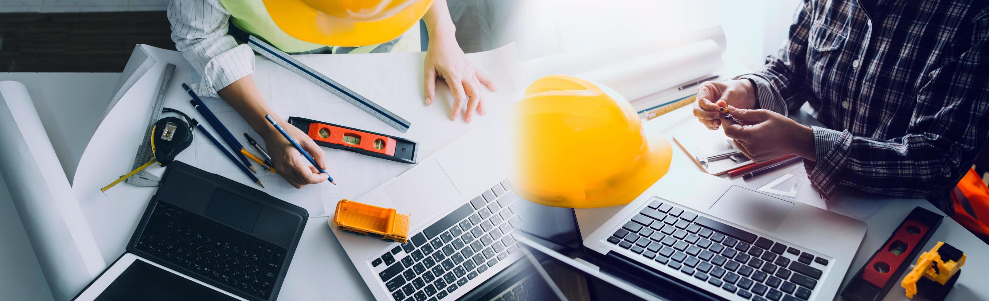 business hand working and laptop with on on architectural project at construction site at office desk in office photo