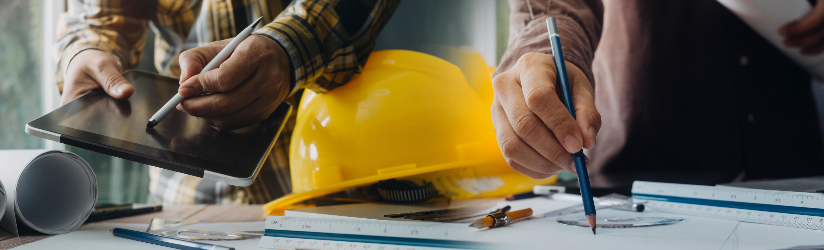 business hand working and laptop with on on architectural project at construction site at office desk in office photo
