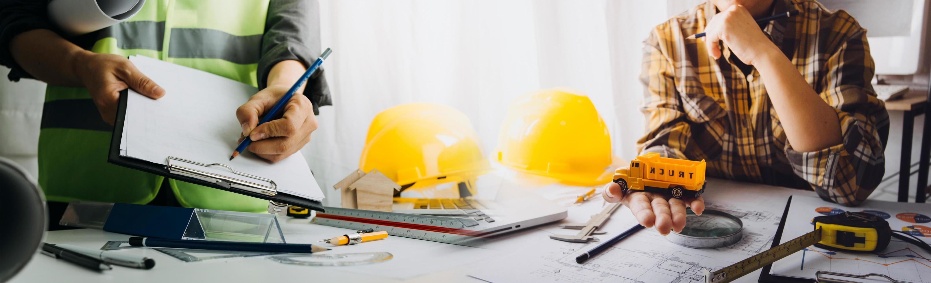 business hand working and laptop with on on architectural project at construction site at office desk in office photo
