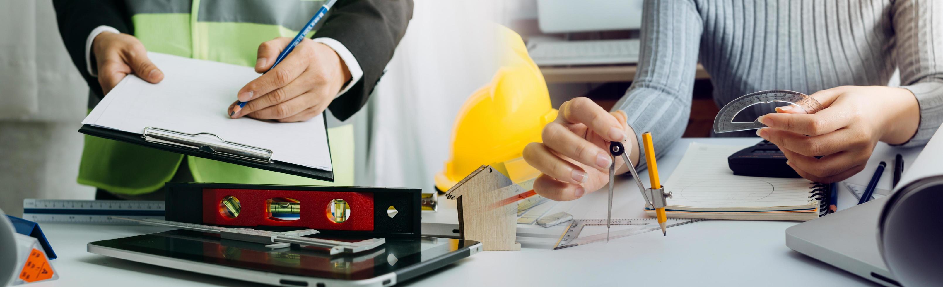 business hand working and laptop with on on architectural project at construction site at office desk in office photo