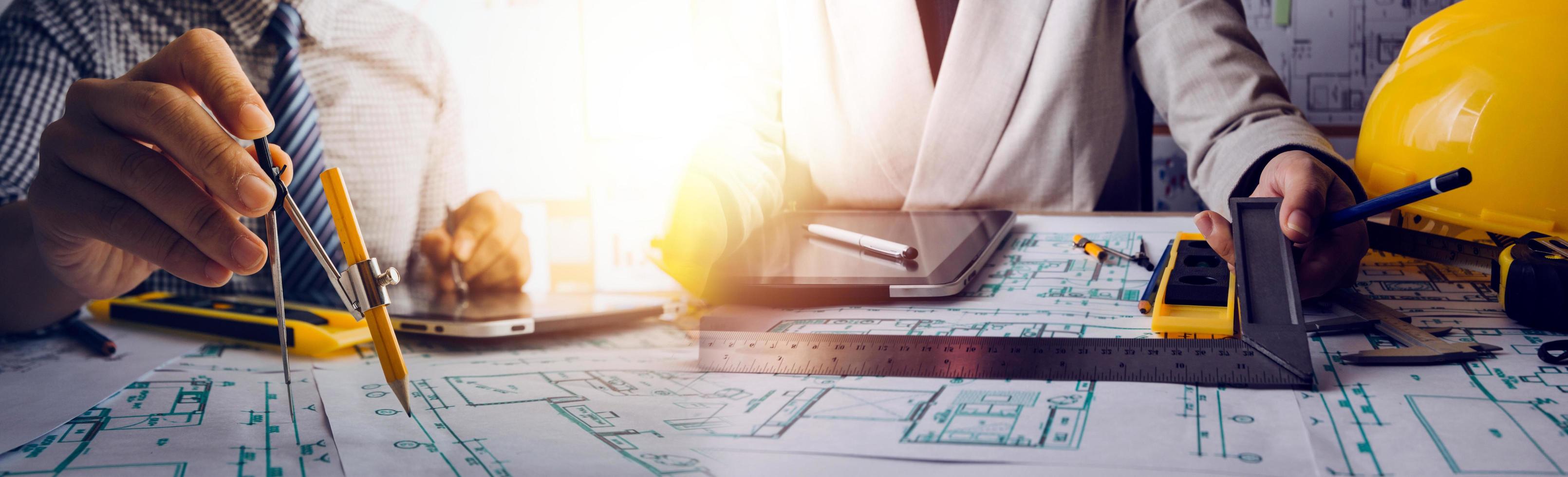 business hand working and laptop with on on architectural project at construction site at office desk in office photo