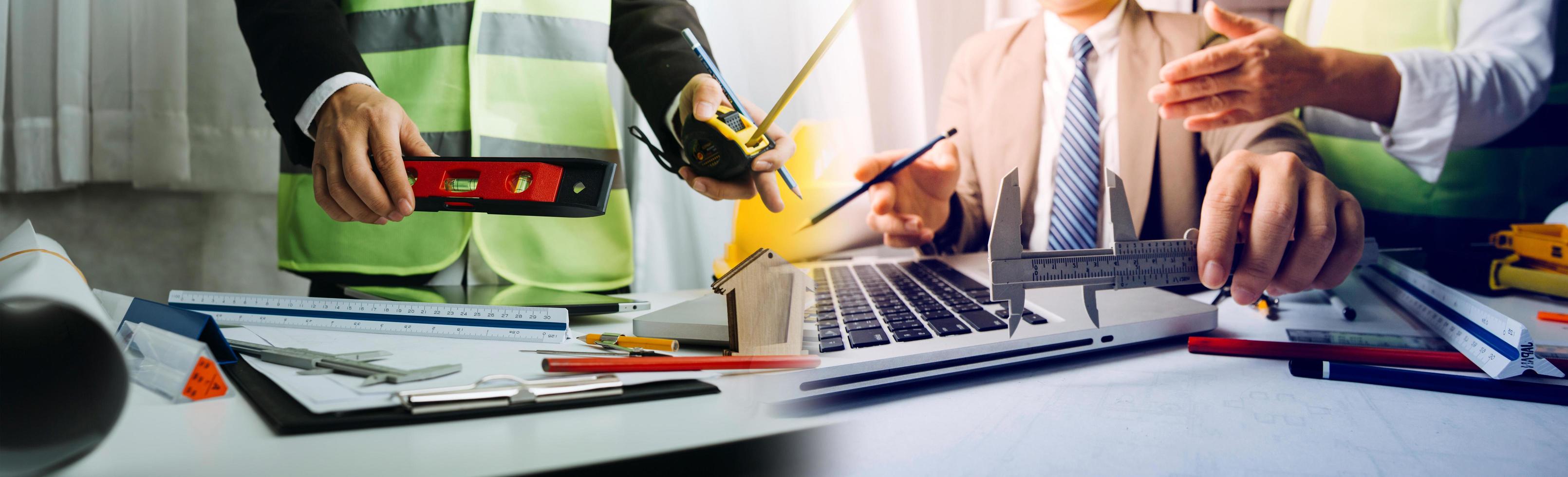 business hand working and laptop with on on architectural project at construction site at office desk in office photo