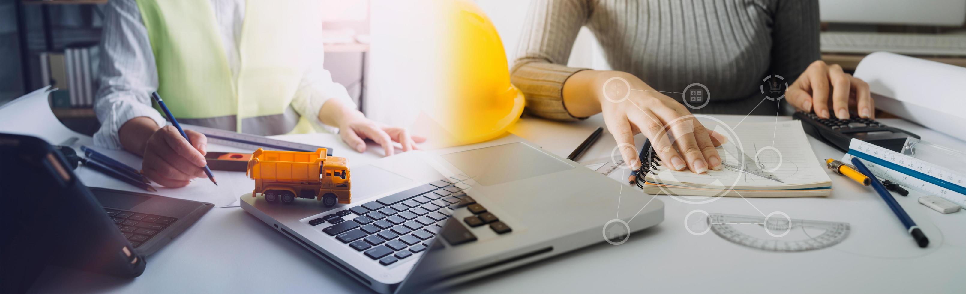 business hand working and laptop with on on architectural project at construction site at office desk in office photo