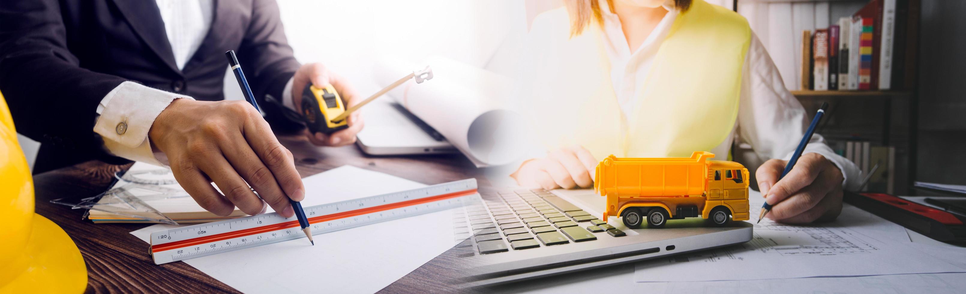 business hand working and laptop with on on architectural project at construction site at office desk in office photo