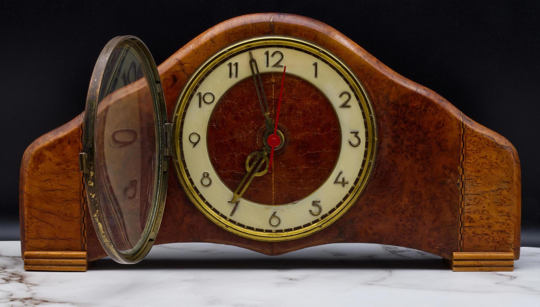 Vintage Italian wooden table clock on marble table and black background. photo