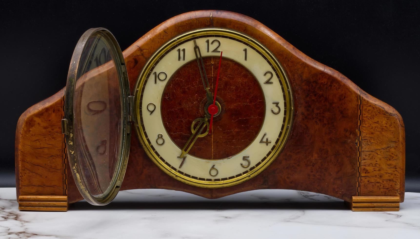 reloj de mesa italiano vintage de madera sobre mesa de mármol y fondo negro. foto