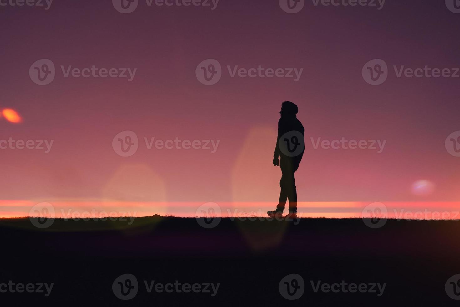 man trekking in the countryside with a beautiful sunset background photo