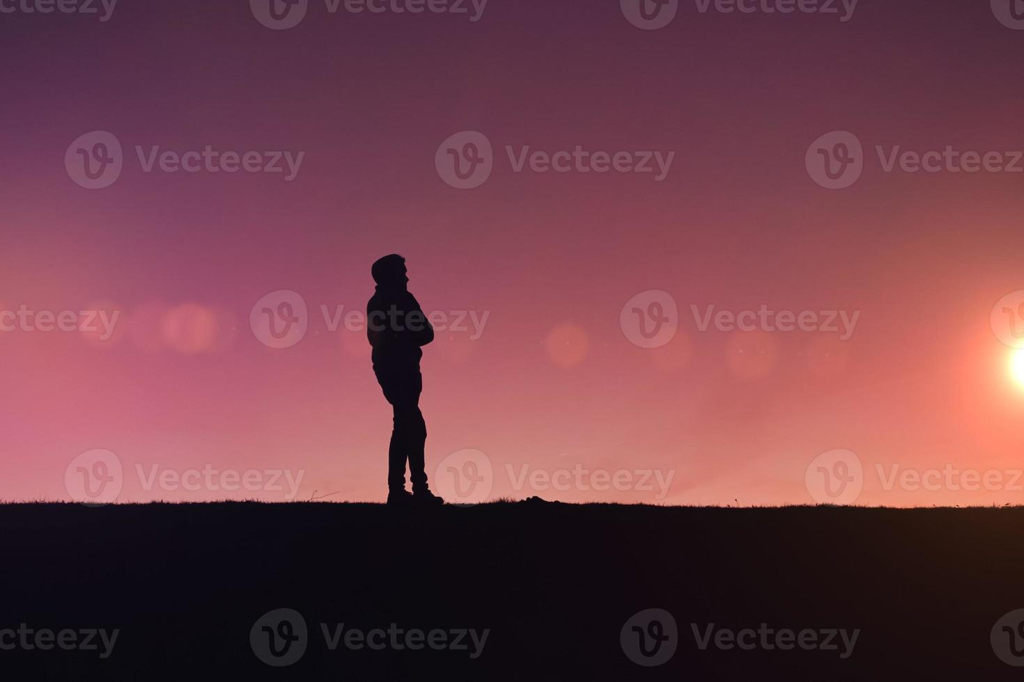 man trekking in the countryside with a beautiful sunset background photo