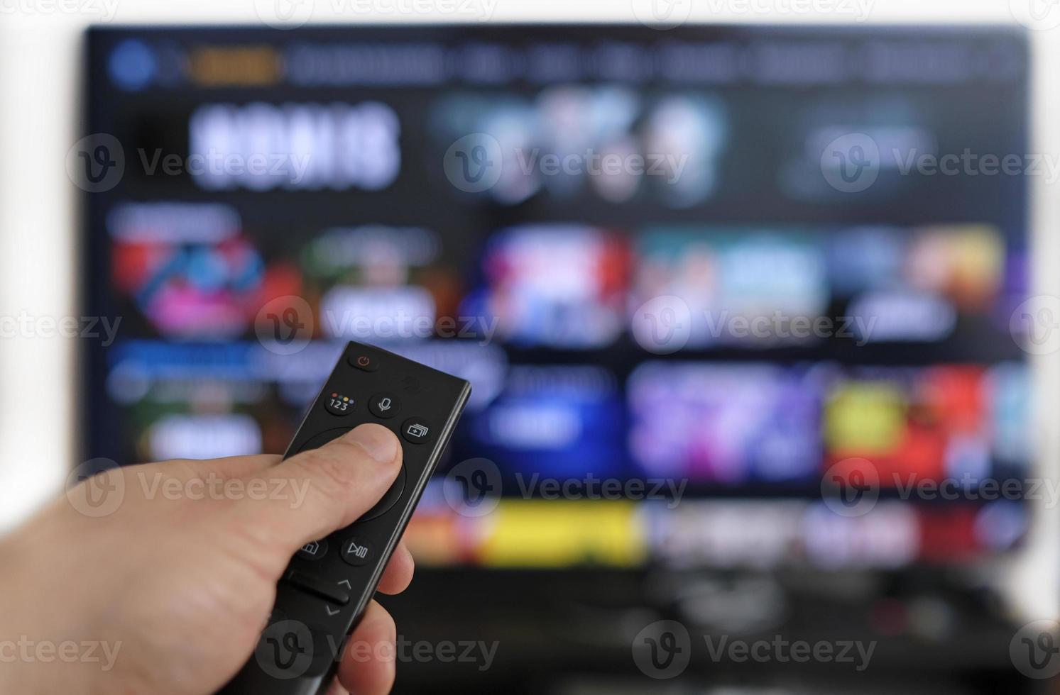 Remote control and screen - binge watching the favorite TV show photo