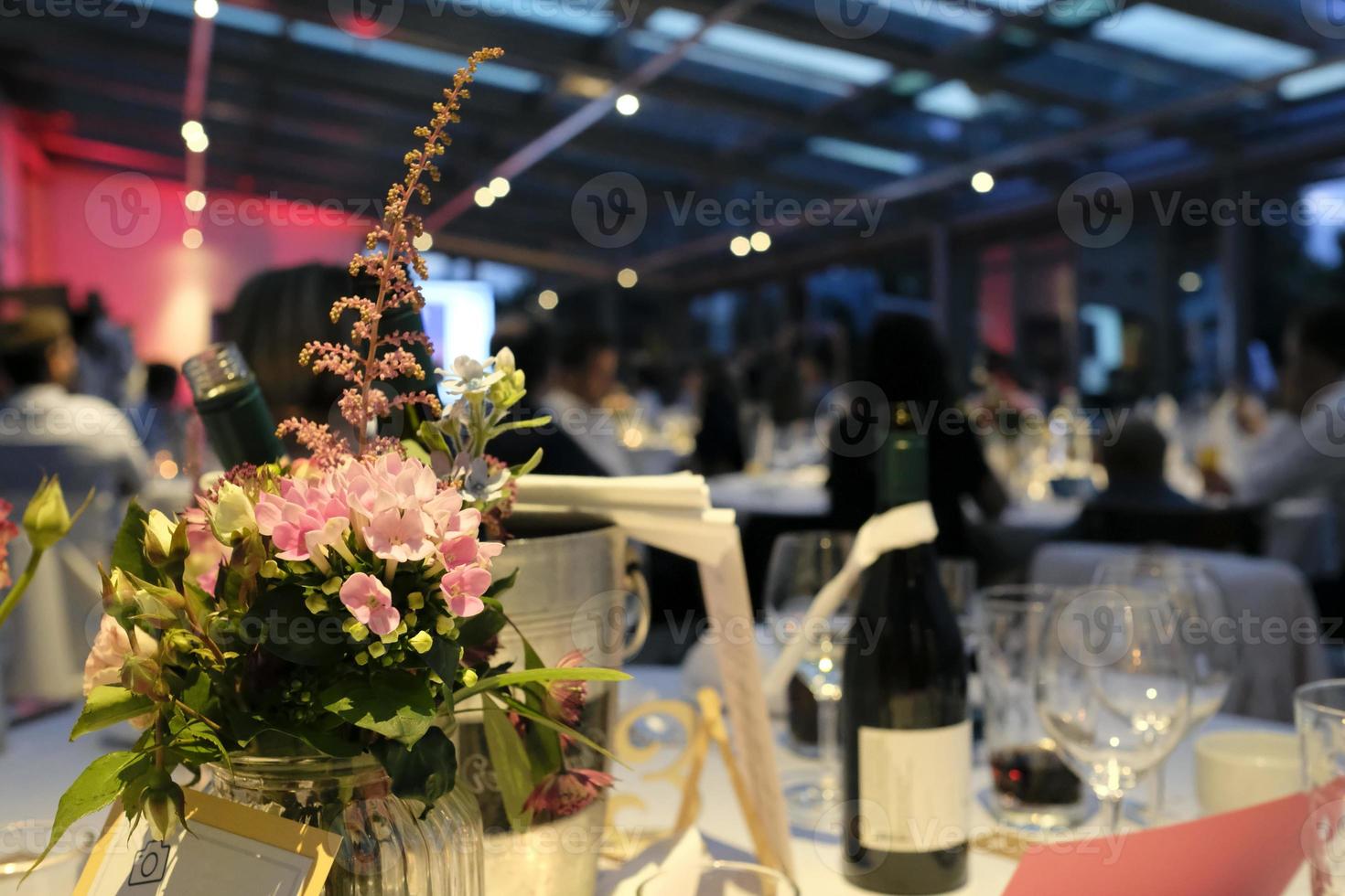 Evening event with flowers and wine bottles on the tables photo