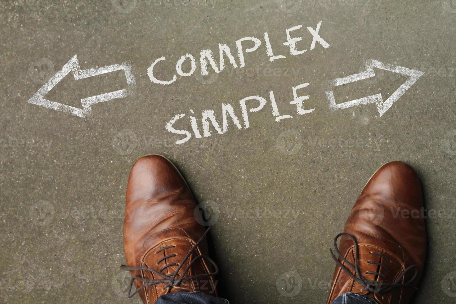 Top view of the words Complex or Simple written on the floor with arrows next to them photo