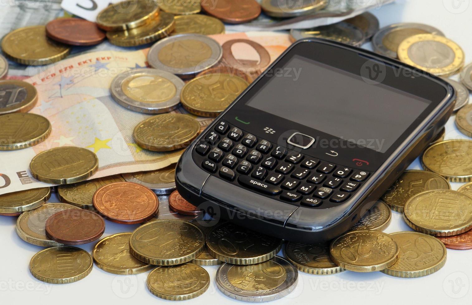 Retro mobile device on a pile of cash photo