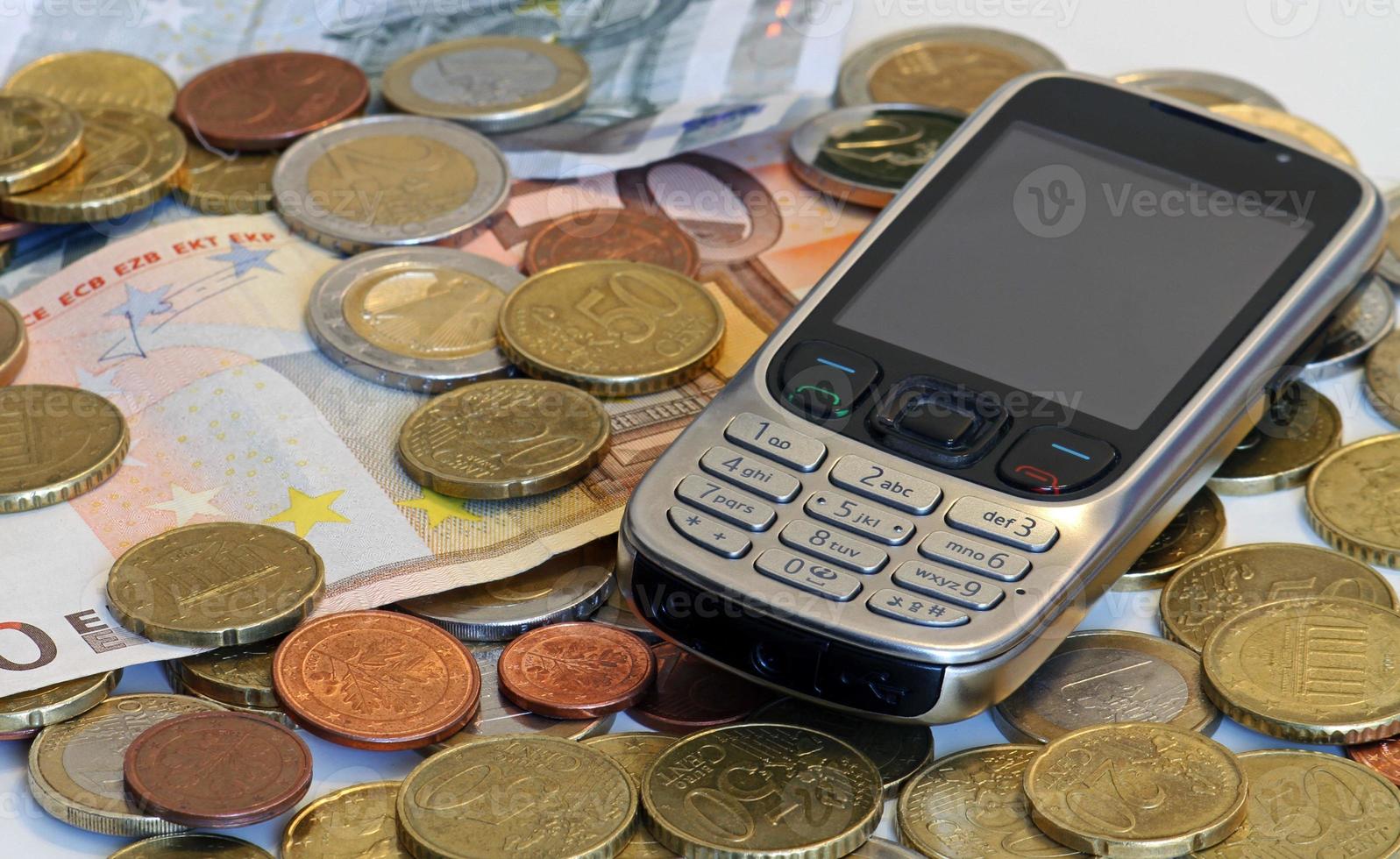 Retro mobile device on a pile of cash photo