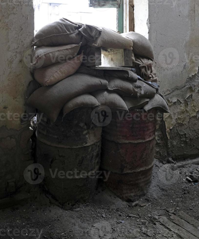 casa abandonada con sacos de arena en la ventana de la línea verde de la zona de amortiguamiento en nicosia, chipre foto