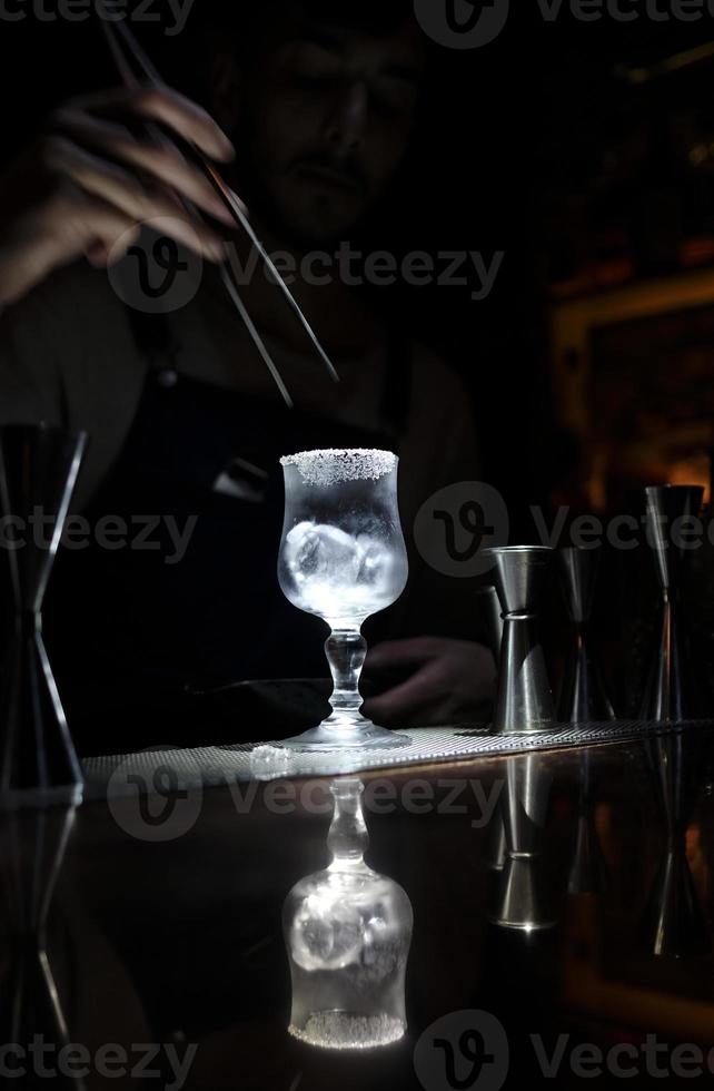 Preparing a cocktail - glass with ice cubes and sugar coating in a cocktail bar photo