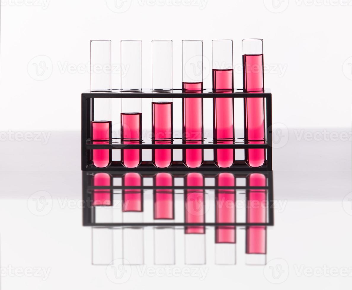 Lab tubes Growth Concept. Several glass tubes on rack with increasing amount of liquid in consecutive tube. Metaphor compare as Science investment research and development bar chart photo