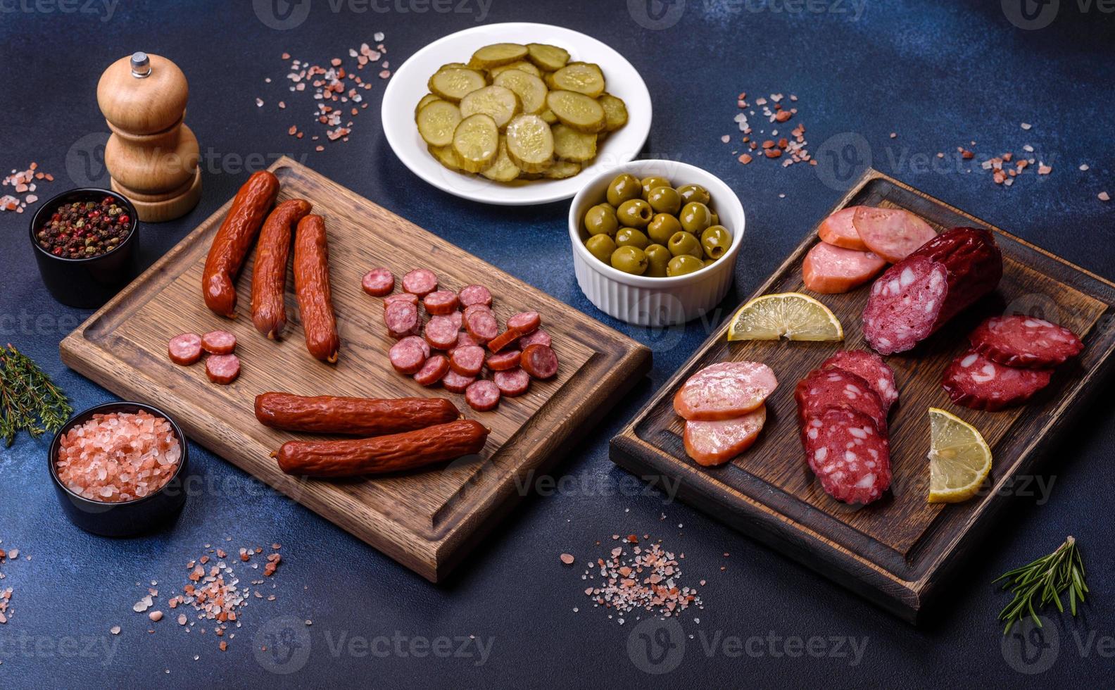 Delicious fresh smoked sausages cut with slices on a wooden cutting board photo