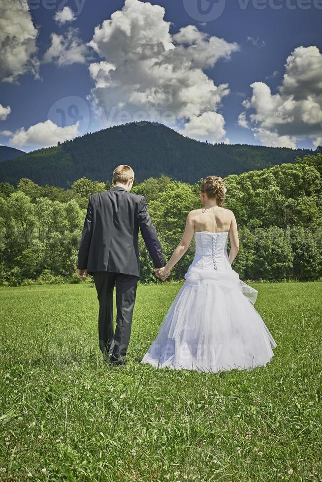Newlyweds in a meadow photo