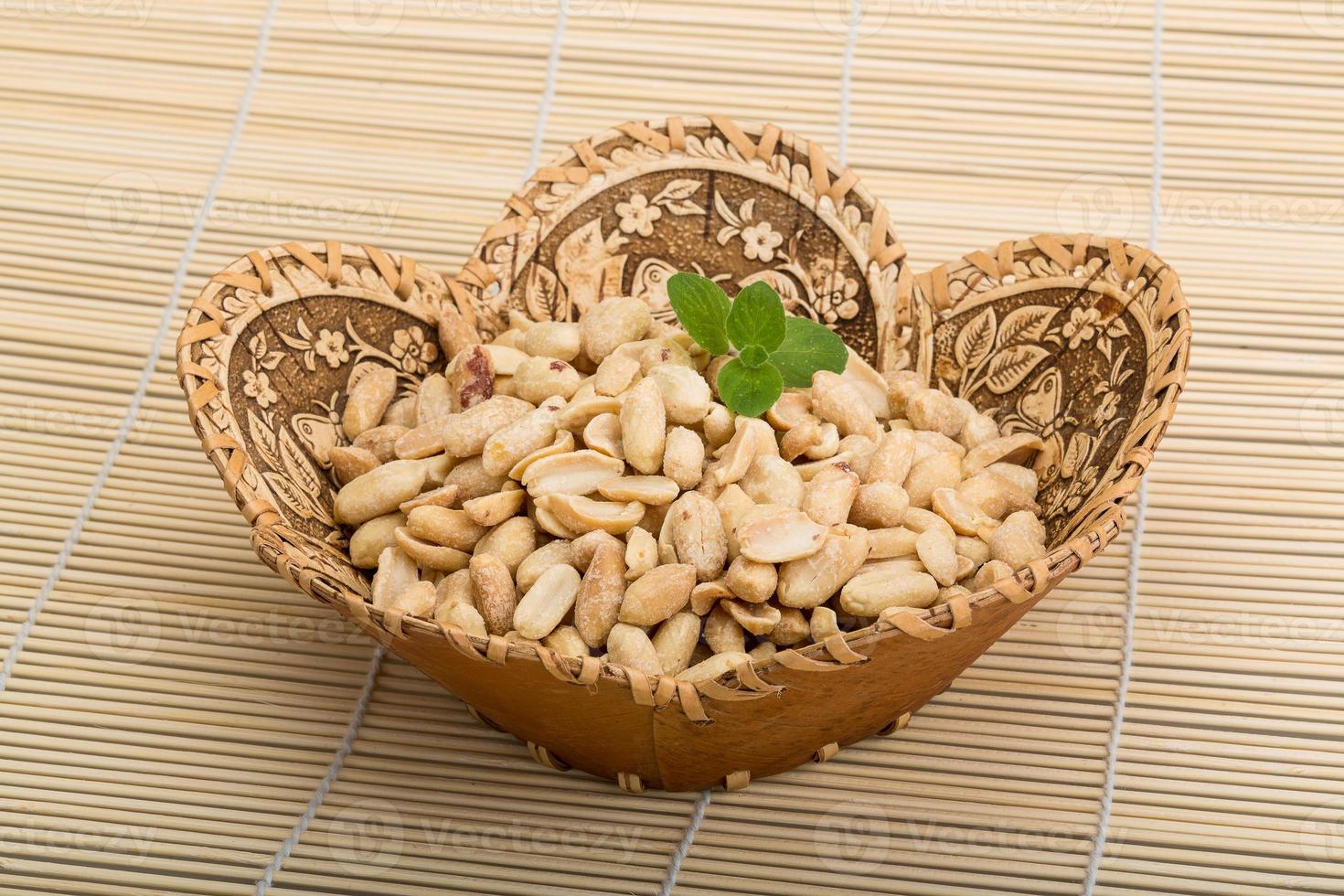 Peanut in a basket on wooden background photo
