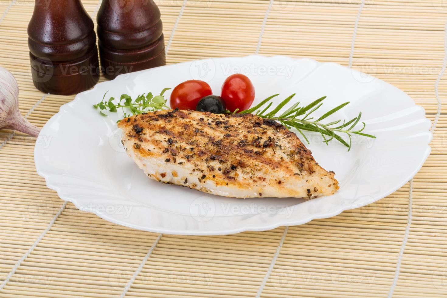 Grilled chichen breast on the plate and wooden background photo