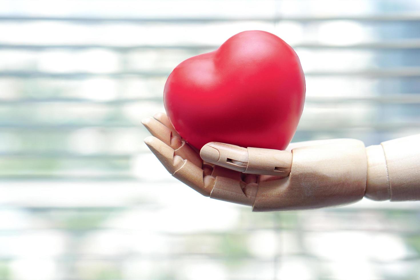 The robot hand is holding a red heart. Medical Technology and future concept. photo