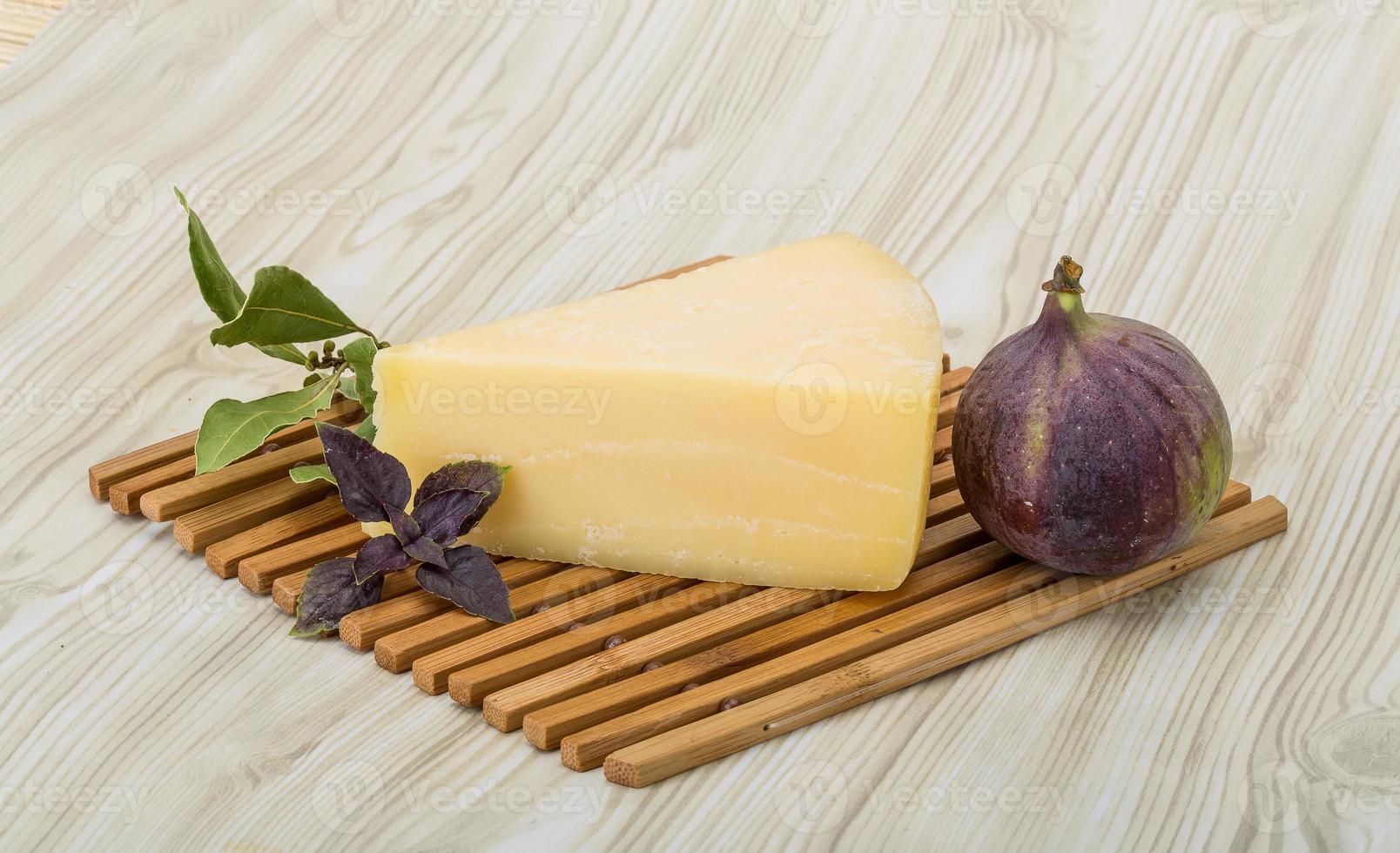 Parmesan cheese on wooden board and wooden background photo