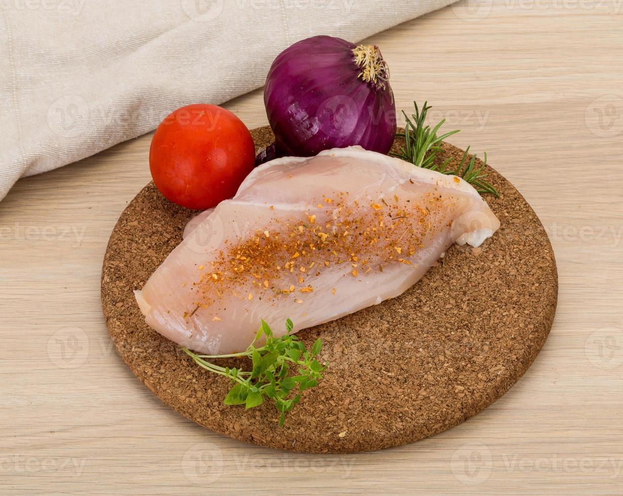 Raw chicken breast on wooden board and wooden background photo