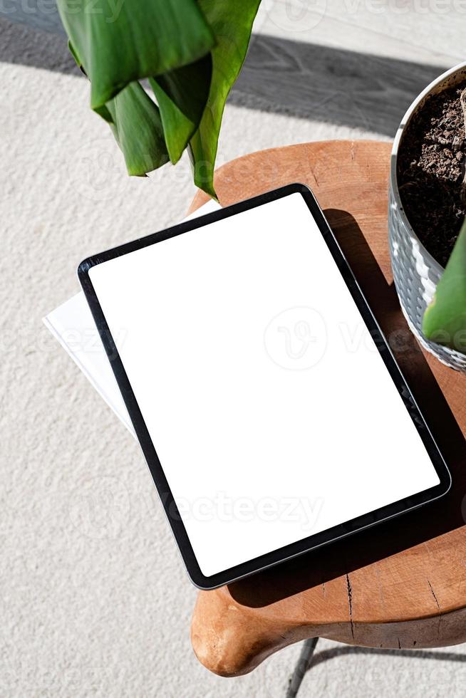 Digital tablet computer with isolated screen on office desk. At home interior. photo