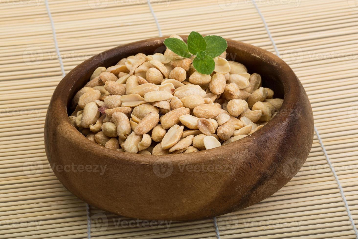 Peanut in a bowl on wooden background photo