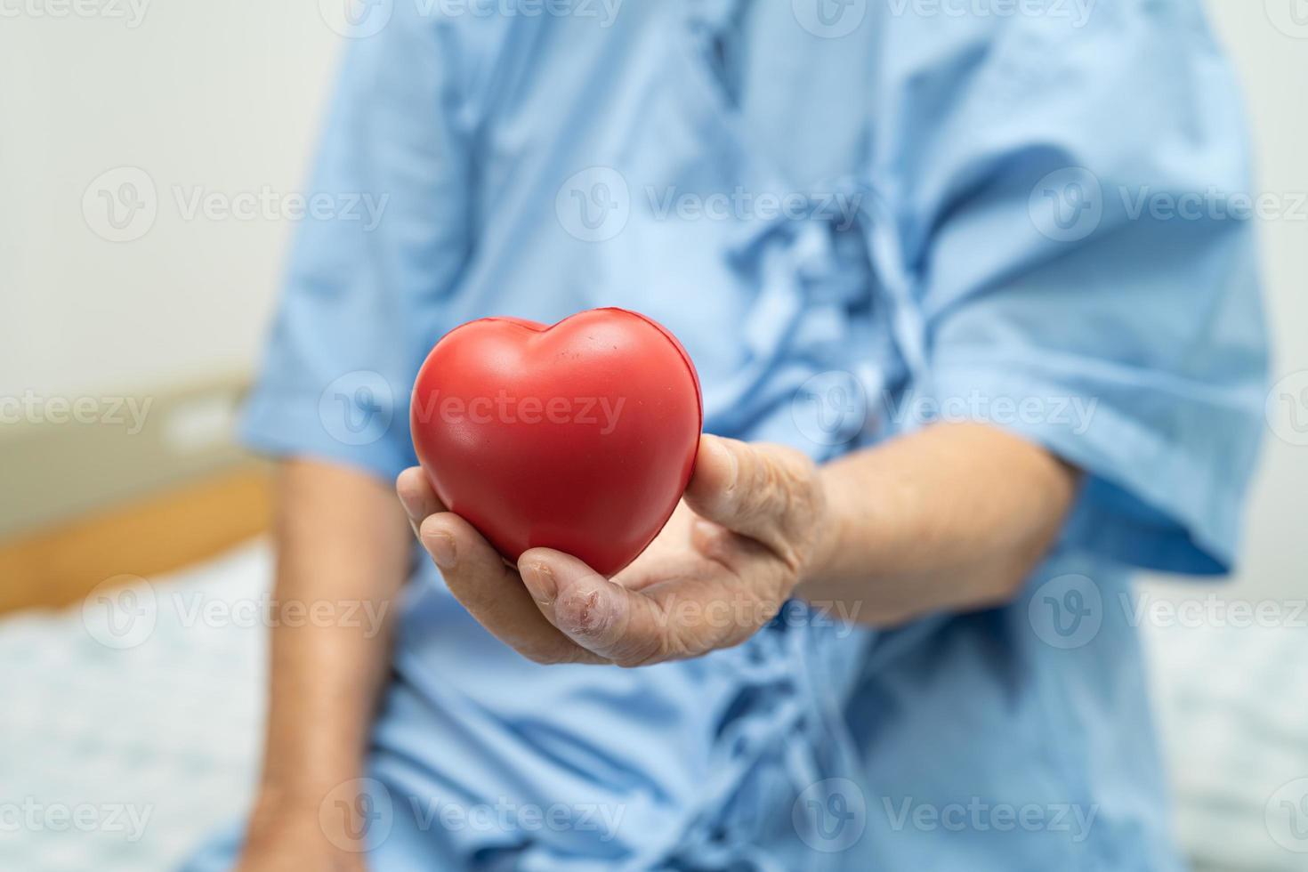 Asian senior or elderly old lady woman patient holding red heart, healthy strong medical concept. photo