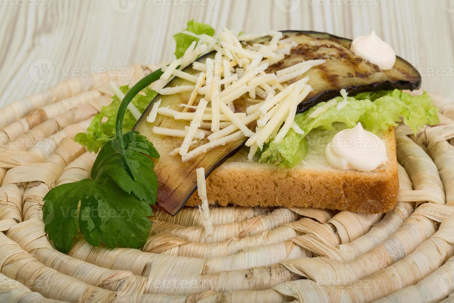 Panini with grilled eggplant on wooden board and wooden background photo