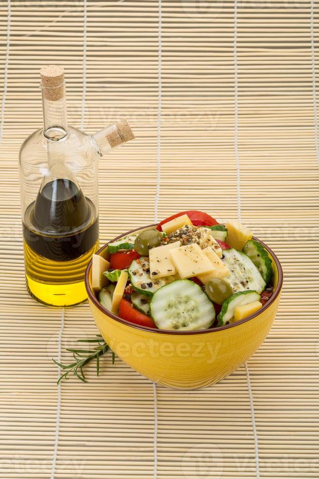 Greek salad in a bowl on wooden background photo