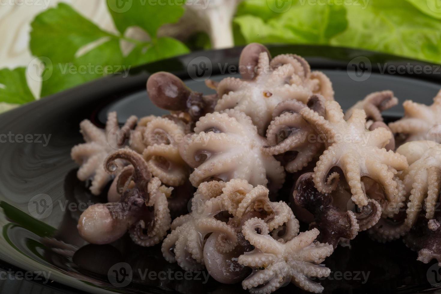 pulpo hervido en el plato y fondo de madera foto