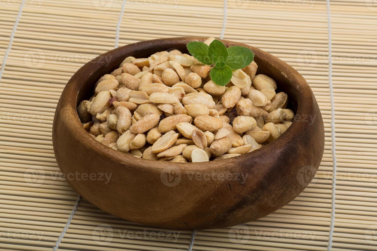 Peanut in a bowl on wooden background photo