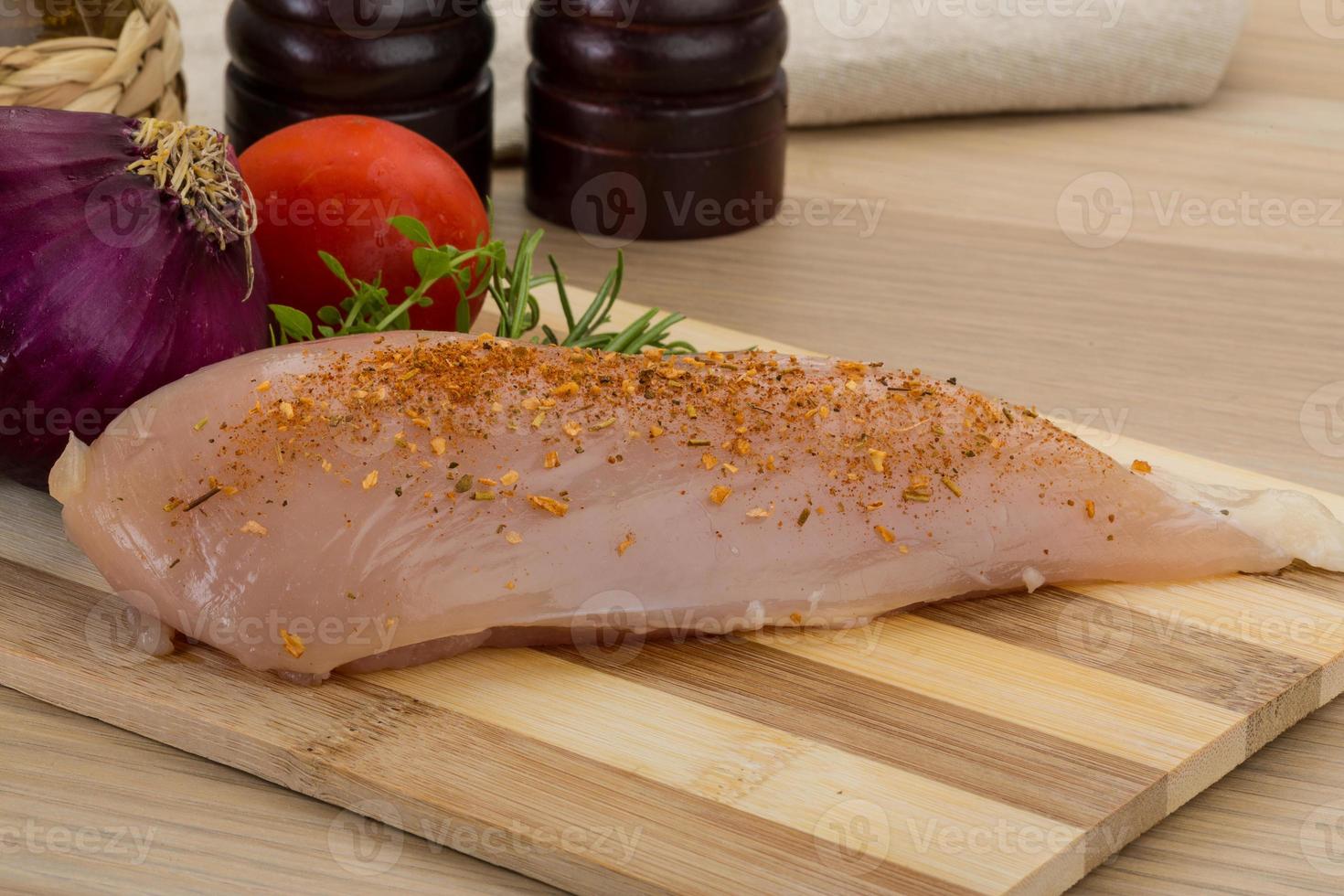 Raw chicken breast on wooden board and wooden background photo