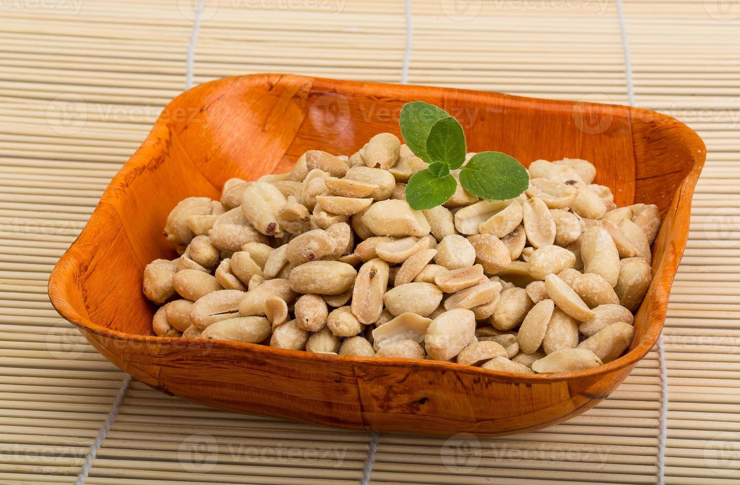 Peanut in a bowl on wooden background photo