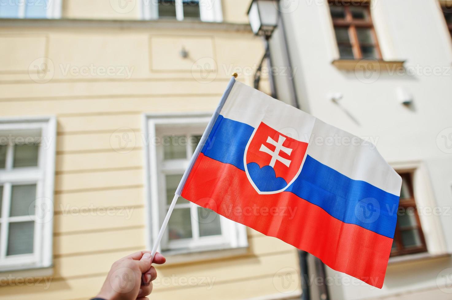 Flag of Slovakia in hand against street of Bratislava. photo