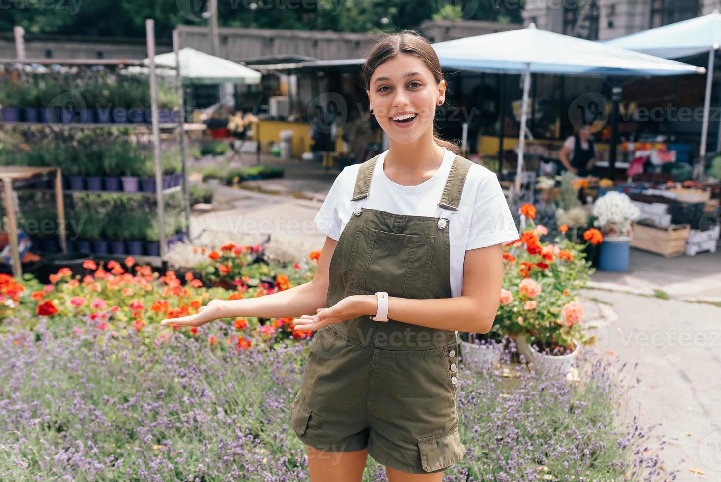 Young woman standing in front of a counter with flowers photo