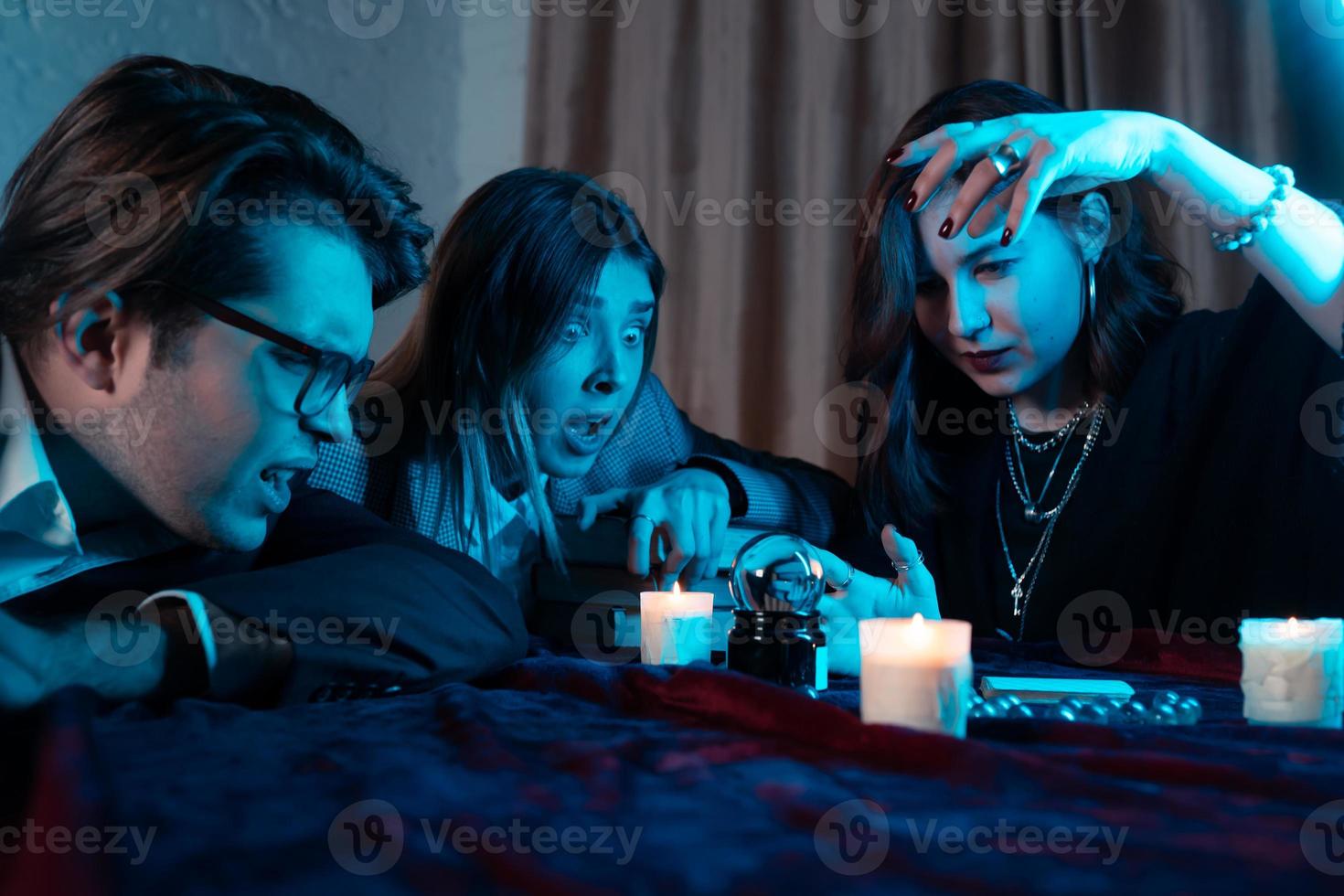 Group of people and woman fortune teller with crystal ball photo