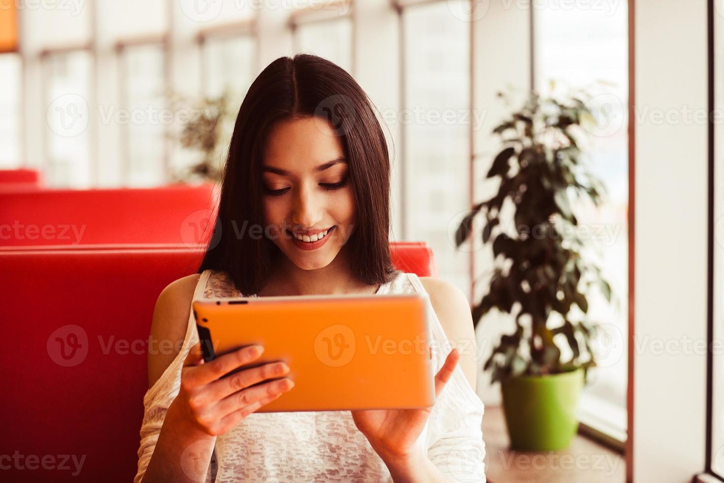 Beautiful girl working on a tablet and smiling.  Instagram toning effect photo
