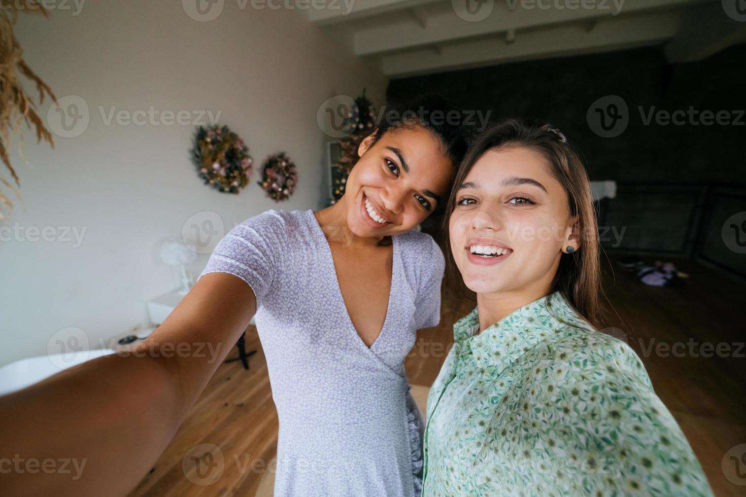 Two girls take selfies in the living room 11728543 Stock Photo at Vecteezy