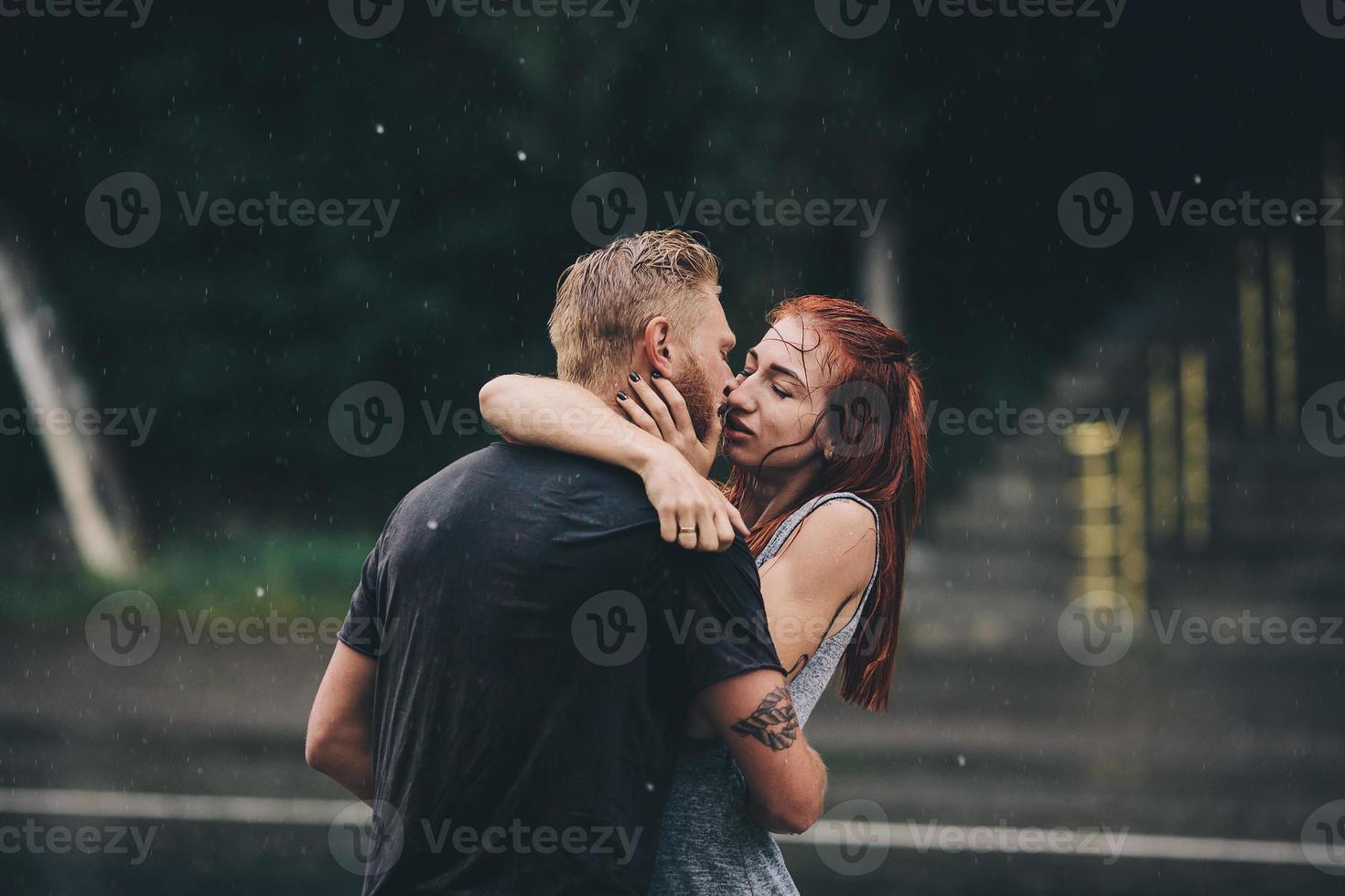 hermosa pareja besándose bajo la lluvia foto